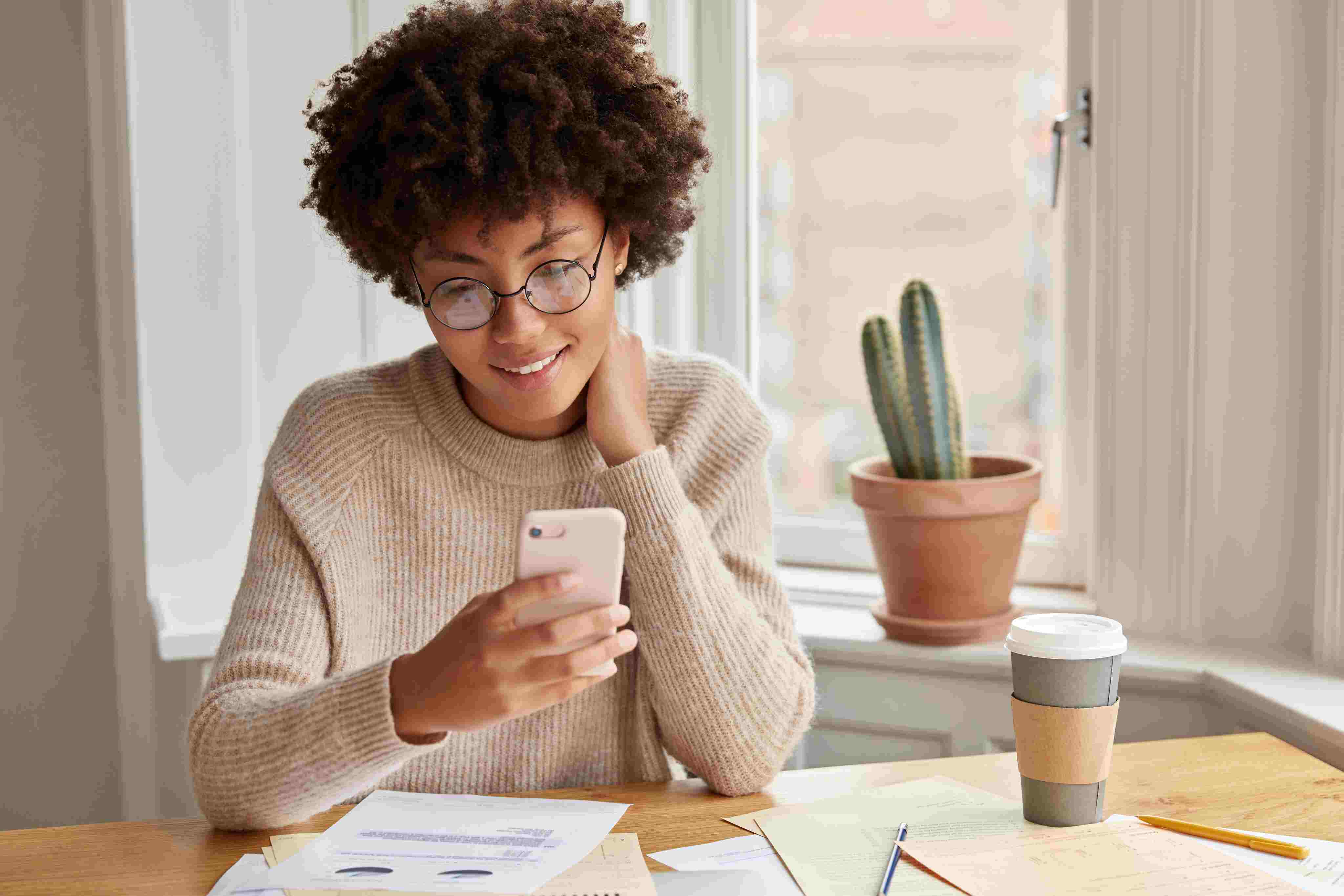 Woman smiling while managing her finances on her phone